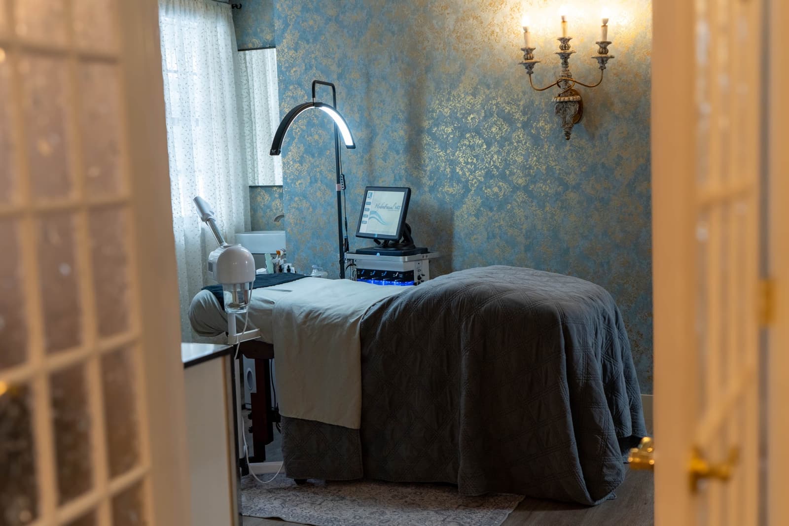 A treatment room at Like No Other Boutique seen through glazed French doors