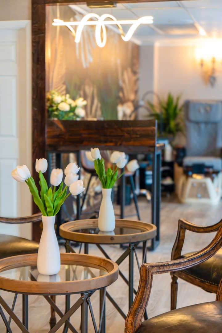 Lobby with glass-topped tables, white tulips and wall sconces