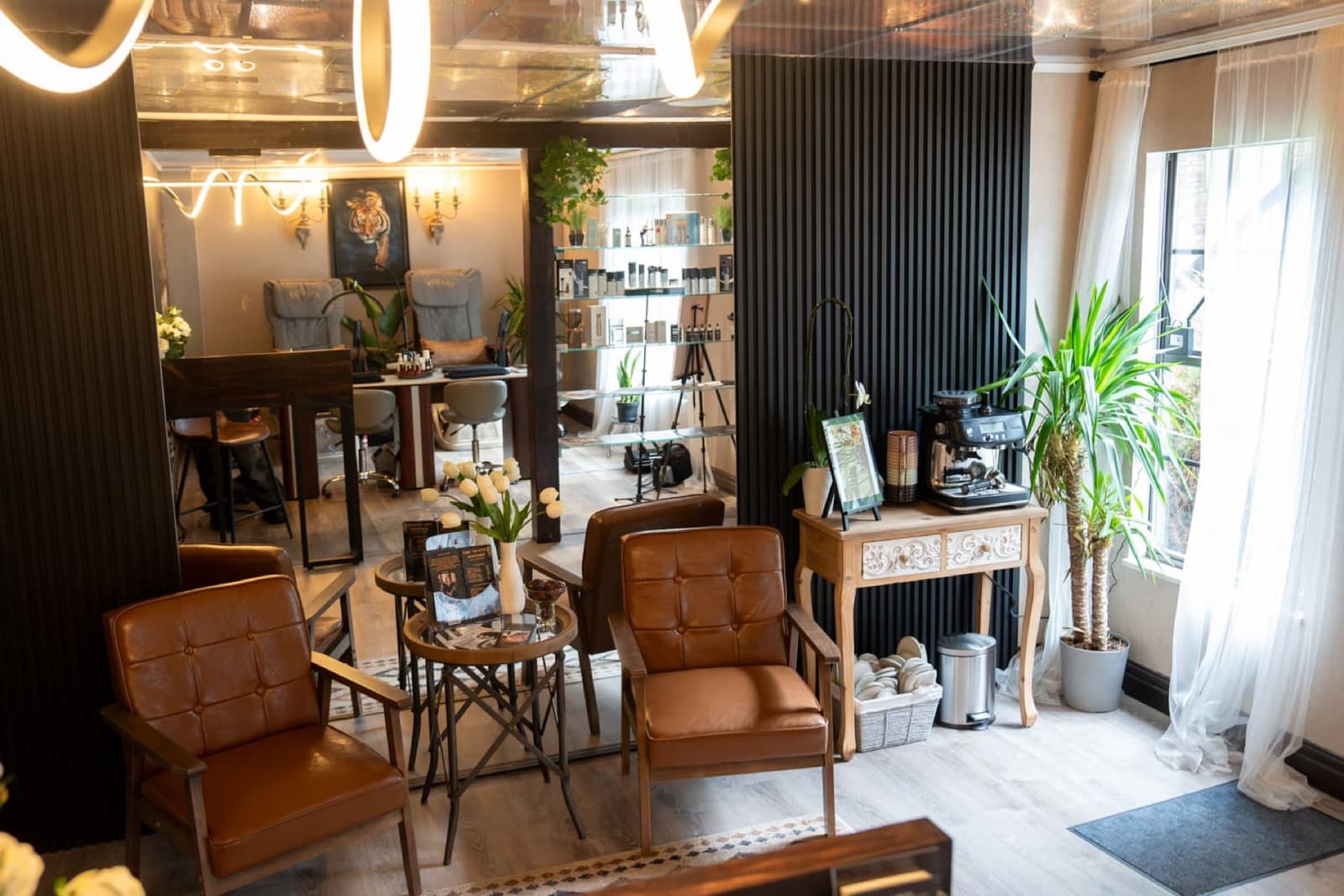 Lounge with leather armchairs, a small table and daylight through sheer curtains