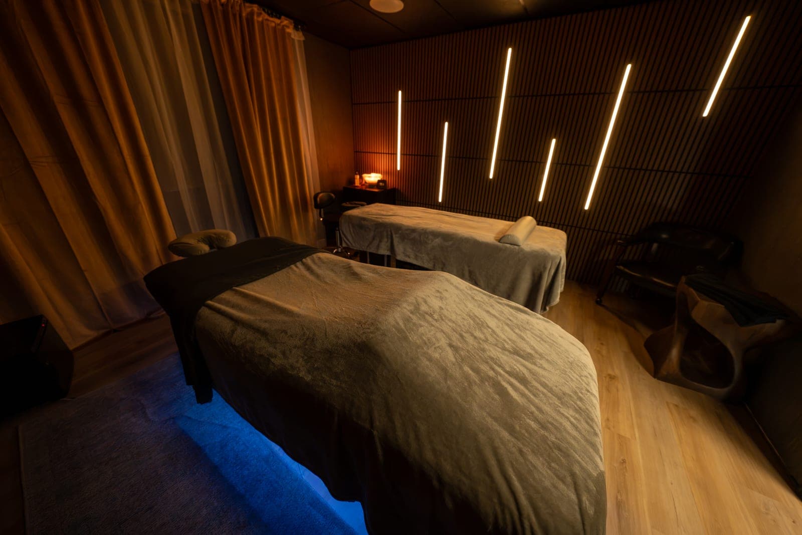 Treatment room with a slatted timber wall and vertical lines of light